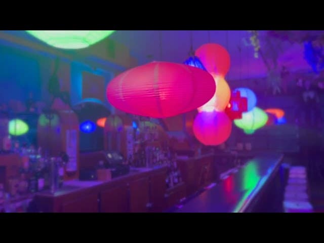 Low-lit tiki bar with tropical cocktails on the counter